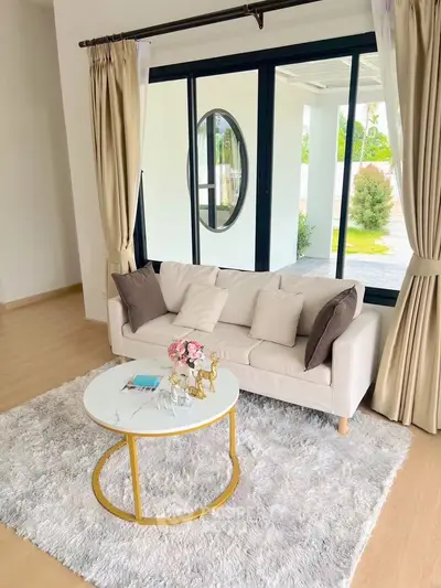 Elegant living room with cozy sofa, plush rug, and large window view.