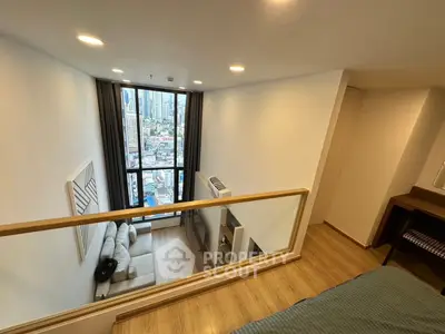Modern loft apartment with city view, featuring a cozy living area and stylish decor.