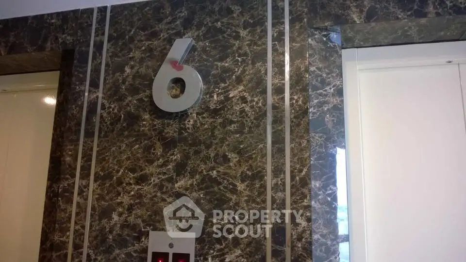 Elegant marble elevator lobby with floor number six prominently displayed.