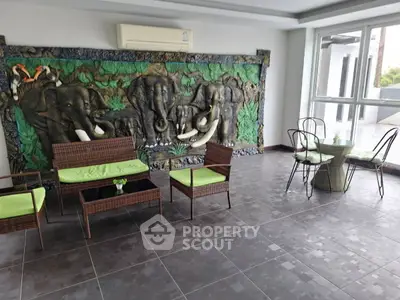 Spacious balcony with unique elephant mural and stylish outdoor furniture.