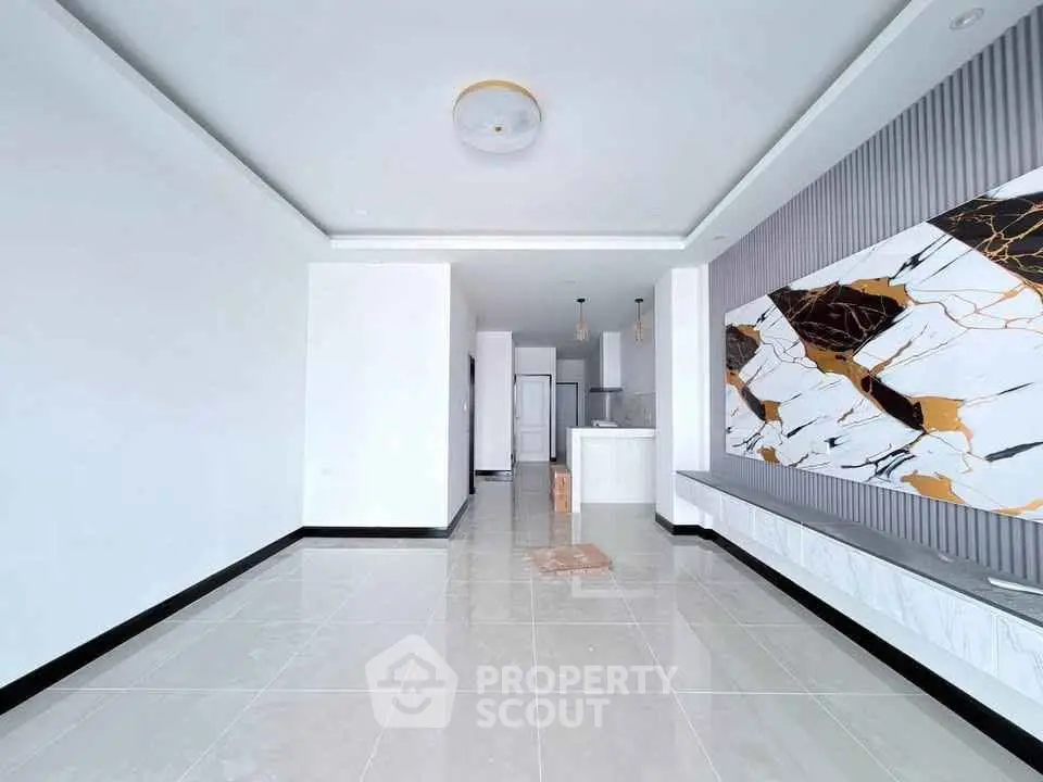 Spacious modern living room with elegant marble accent wall and open layout.