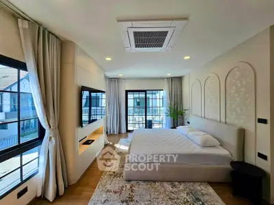 Luxurious bedroom with large windows and modern decor in a stylish home.