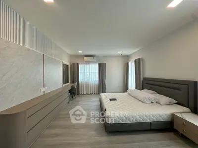 Spacious modern bedroom with sleek design and ample natural light
