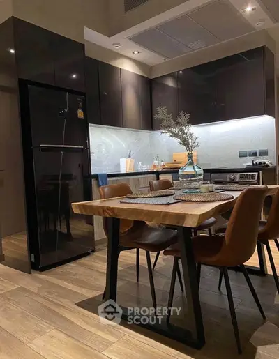 Modern kitchen with sleek cabinets, wooden dining table, and stylish chairs in a contemporary apartment.