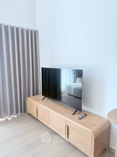Modern living room with sleek TV stand and large flat-screen TV, perfect for entertainment.