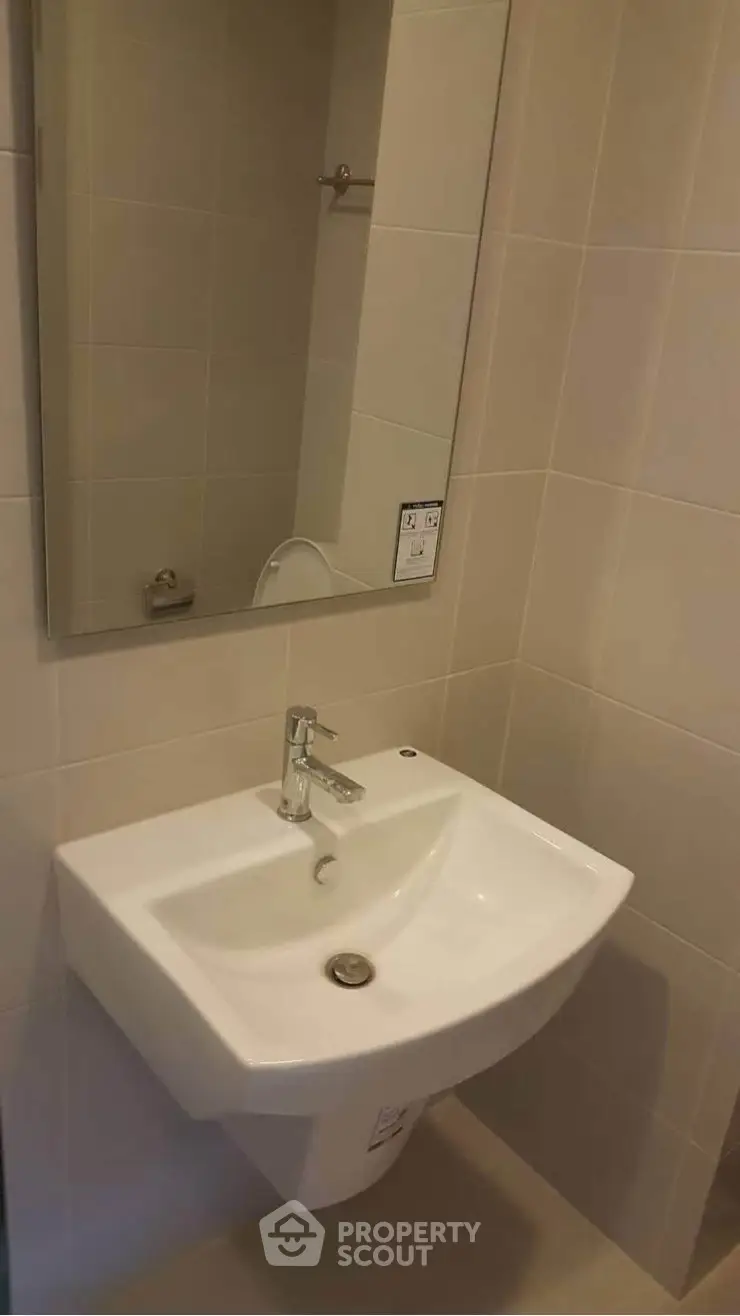Modern bathroom with sleek sink and mirror in a contemporary apartment.