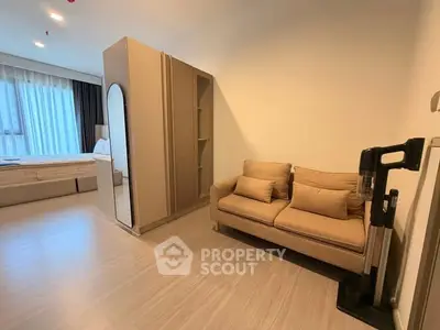 Modern studio apartment with cozy sofa and sleek wardrobe, featuring a stylish open layout and ample natural light.