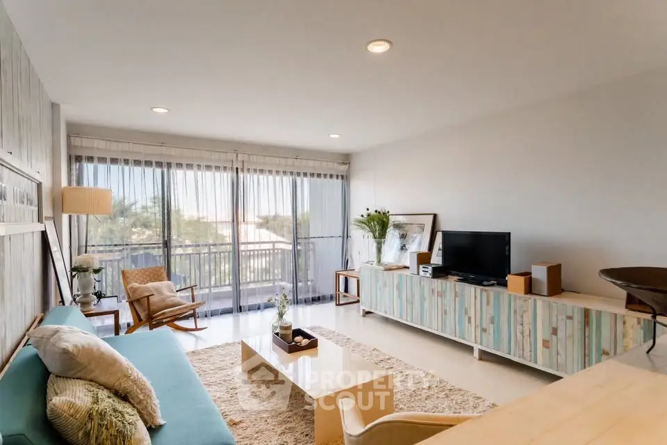 Stylish living room with modern decor and large windows offering natural light and a cozy atmosphere.