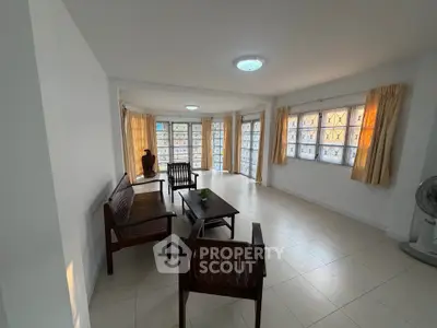 Spacious living room with natural light and elegant wooden furniture