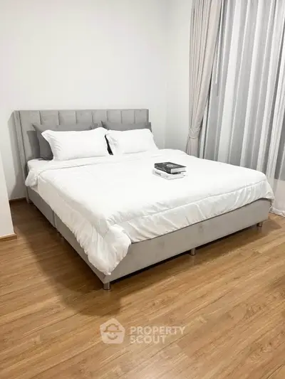 Modern bedroom with stylish bed and wooden flooring, perfect for a cozy retreat.