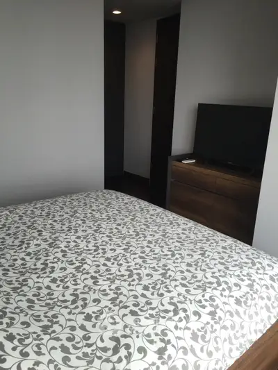 Modern bedroom with stylish decor and flat-screen TV, perfect for urban living.