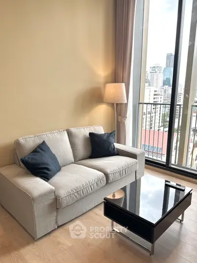 Modern living room with cozy sofa and city view from large windows.