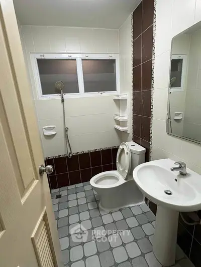 Modern bathroom with sleek fixtures and tiled walls, featuring a shower and toilet.