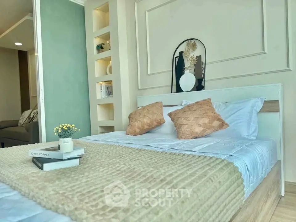 Stylish bedroom with modern decor and cozy bedding in a well-lit apartment.