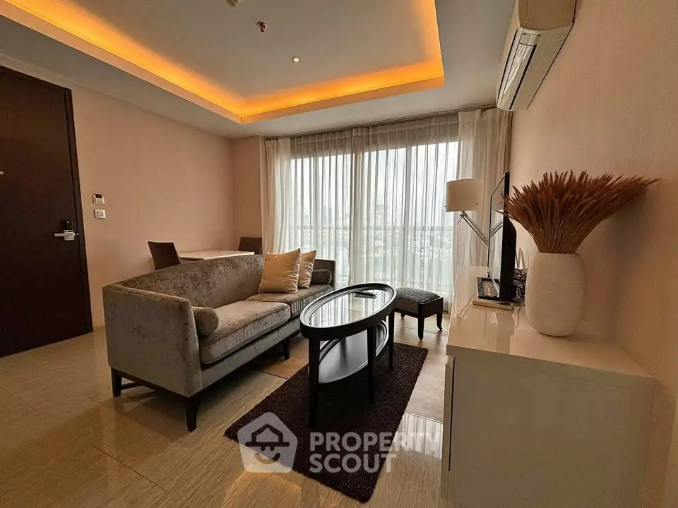 Elegant living room with modern furniture and large windows offering natural light.