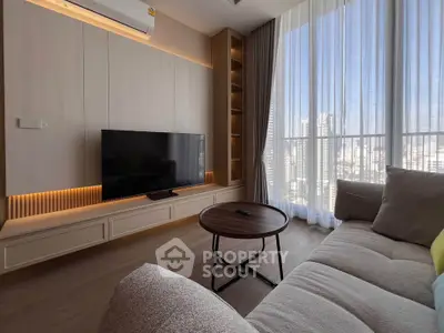 Modern living room with large window and city view, featuring cozy sofa and sleek TV setup.