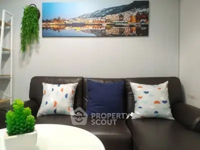 Cozy living room with modern decor and stylish cushions on a leather sofa, perfect for relaxation.