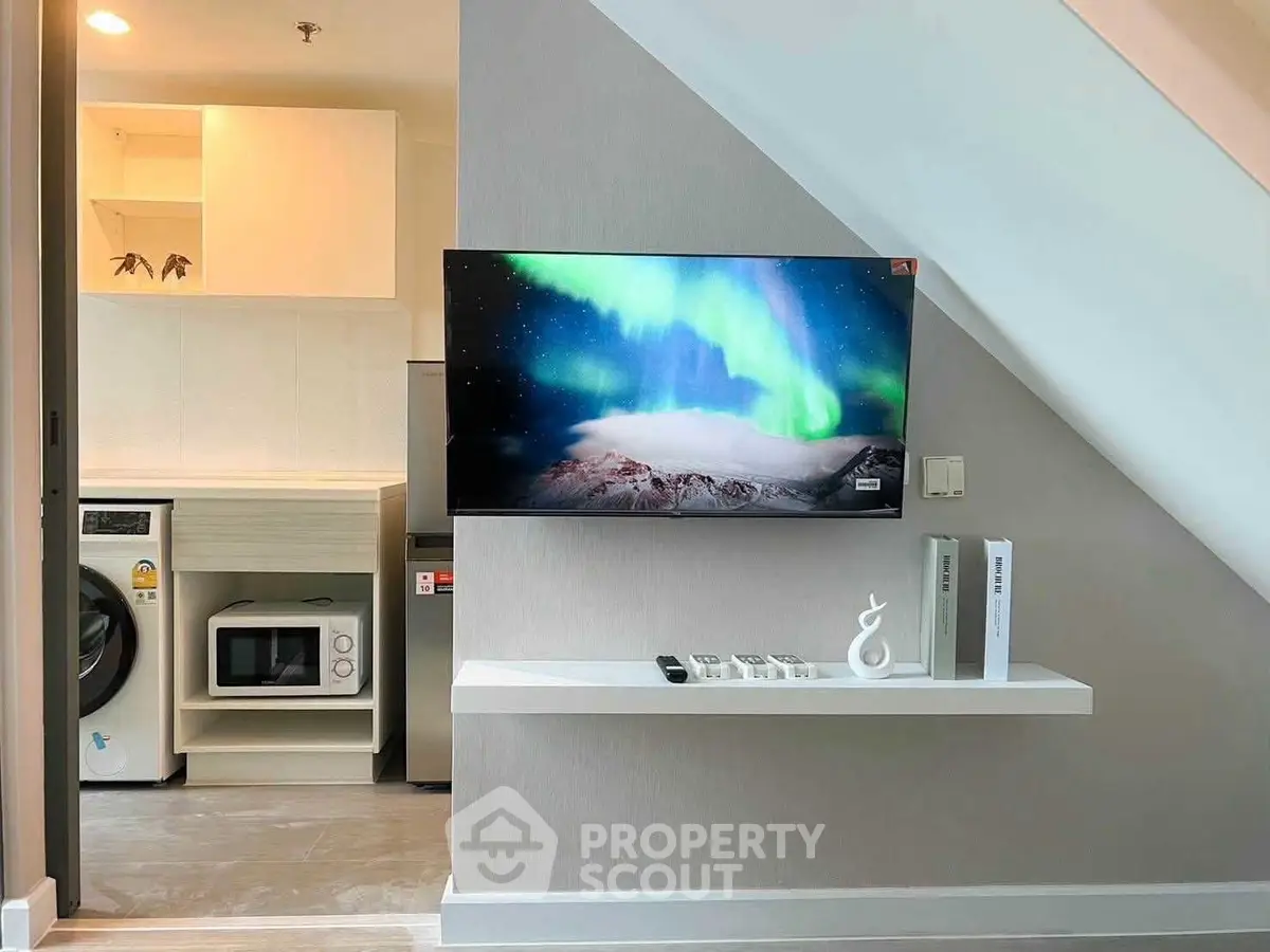 Modern interior with sleek appliances and stylish decor under staircase