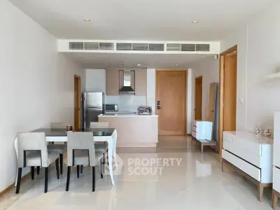 Modern open-plan kitchen and dining area with sleek furniture and stainless steel appliances.