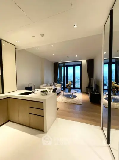 Modern open-plan living room with kitchen, featuring sleek design and city view.