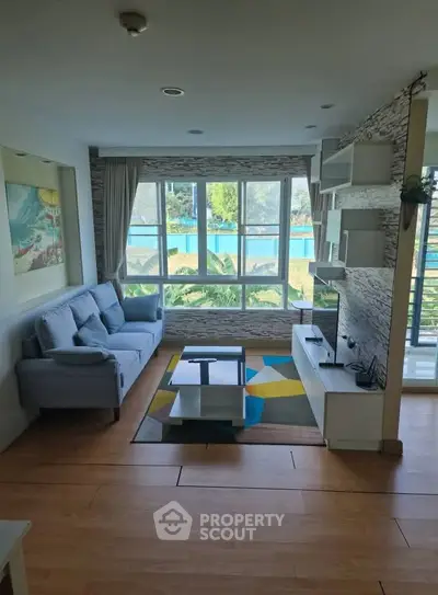 Spacious living room with large windows and modern decor, offering a bright and inviting atmosphere.