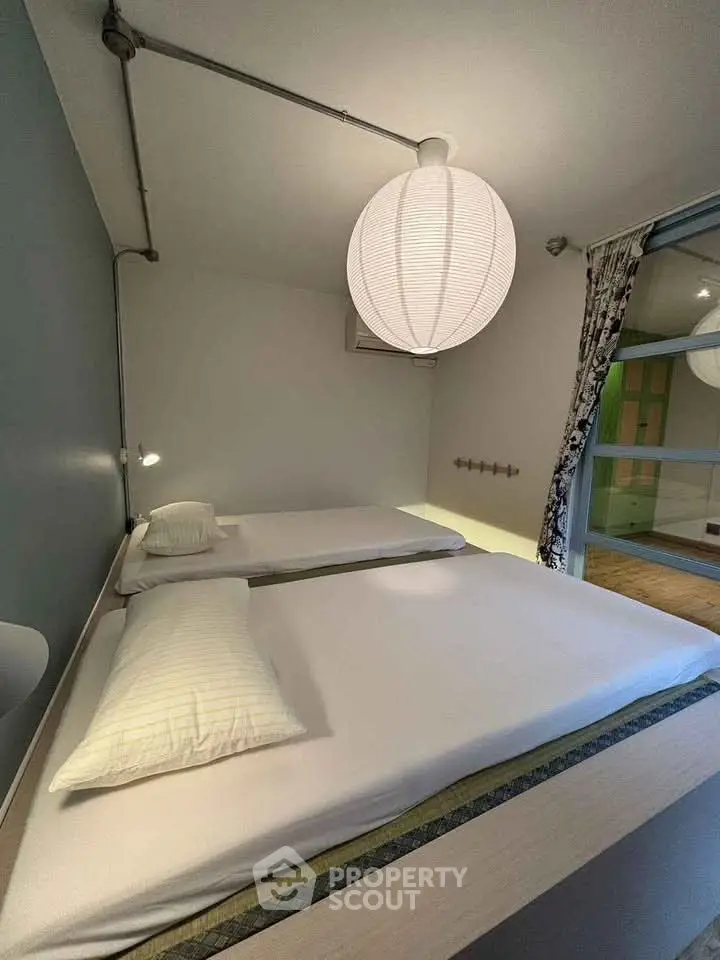 Modern bedroom with minimalist design and stylish lighting in a contemporary apartment.
