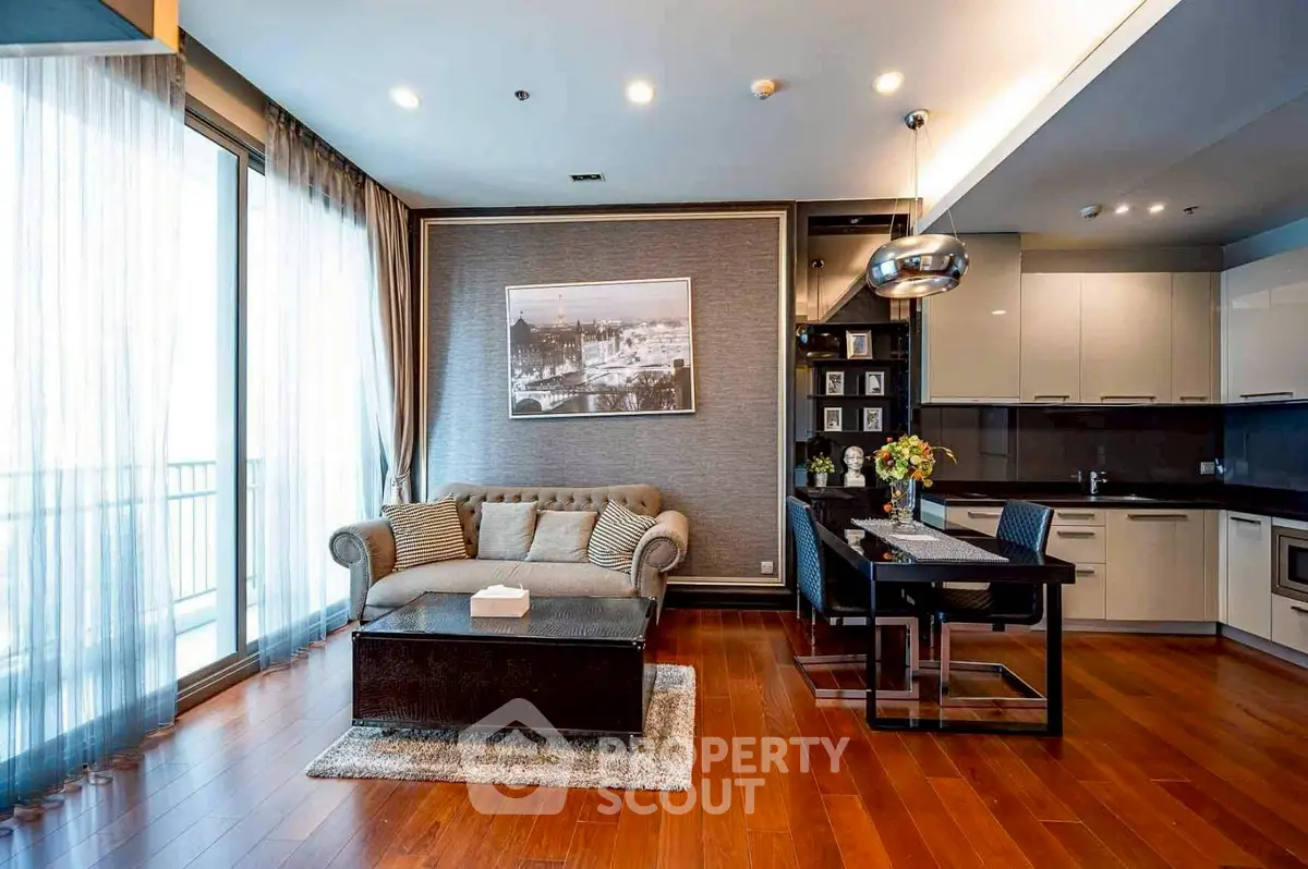 Modern living room with open kitchen, hardwood floors, and stylish decor