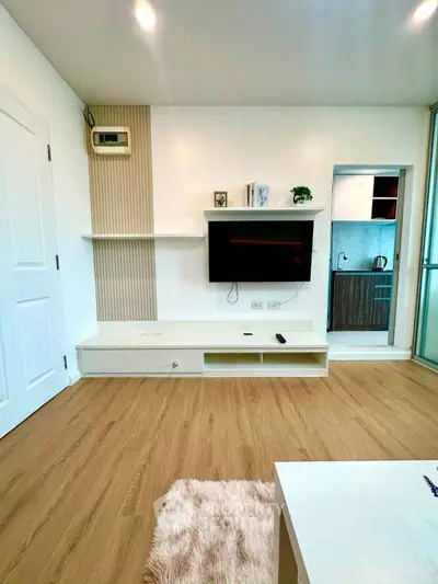 Modern living room with wall-mounted TV and sleek wooden flooring