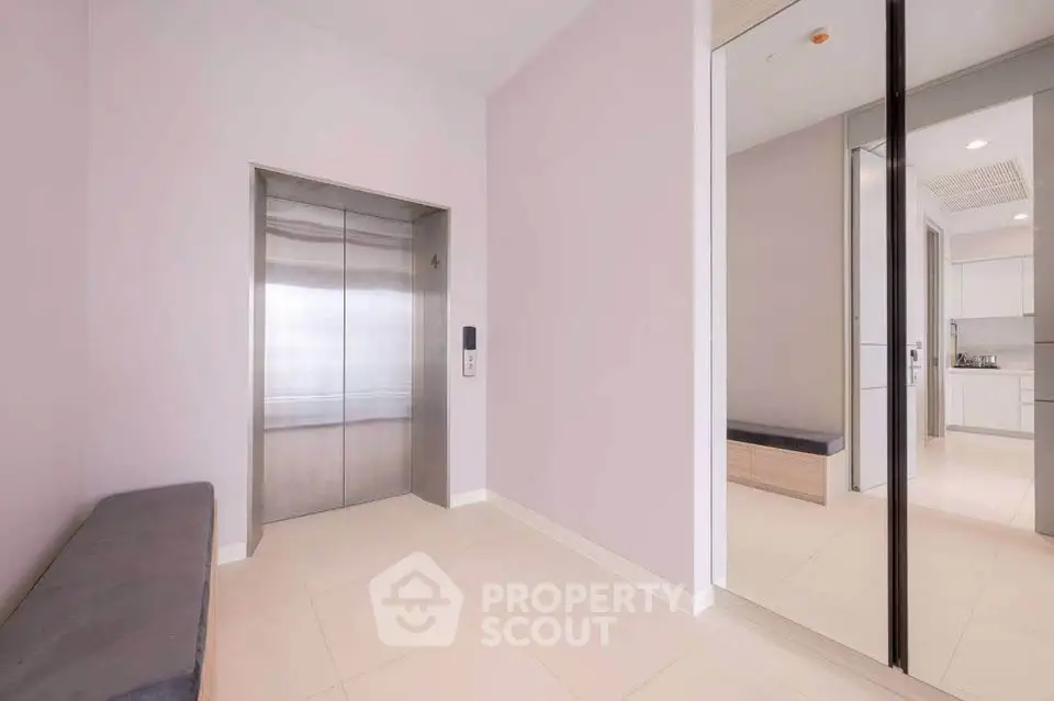 Modern apartment elevator lobby with sleek design and mirrored walls.