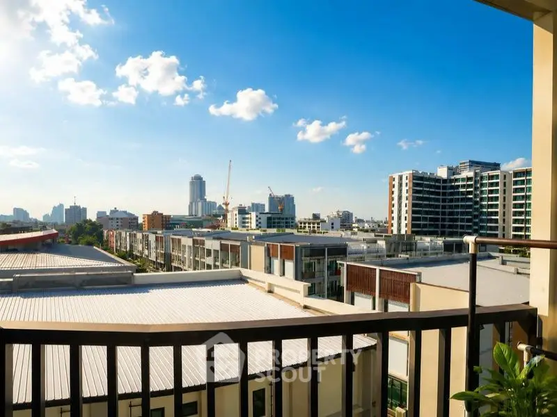 Stunning cityscape view from a modern balcony with clear blue skies.