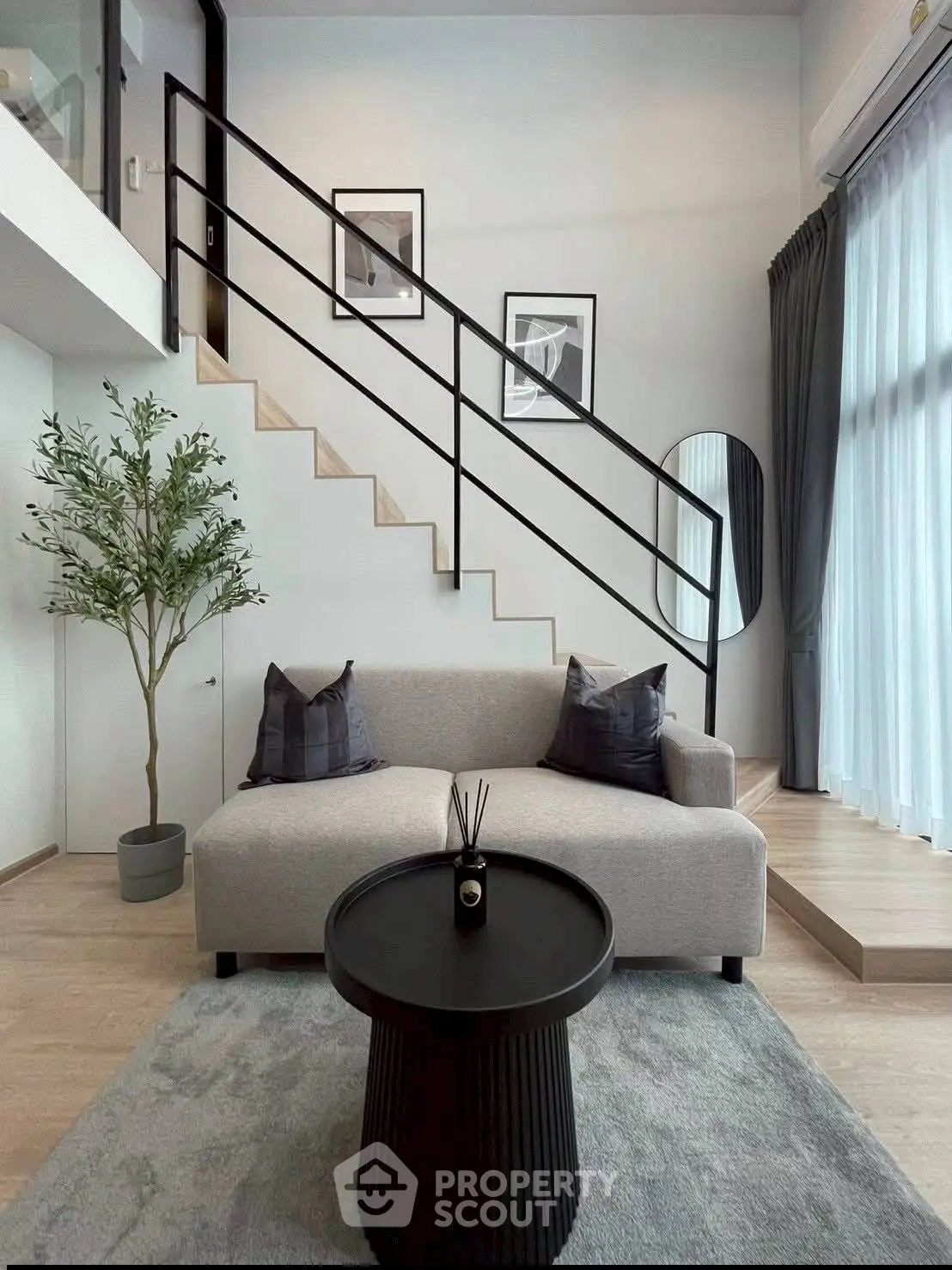 Modern living room with stylish staircase and cozy seating area.
