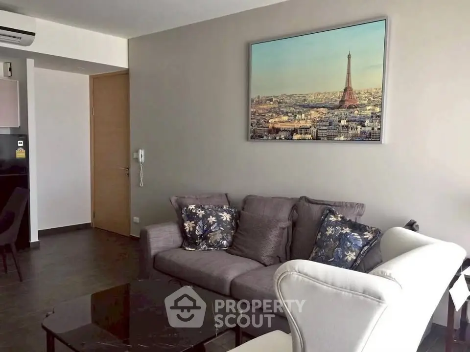 Modern living room with stylish furniture and Paris-themed wall art, perfect for urban living.