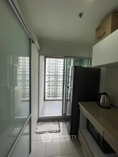 Compact kitchen with balcony view in modern apartment