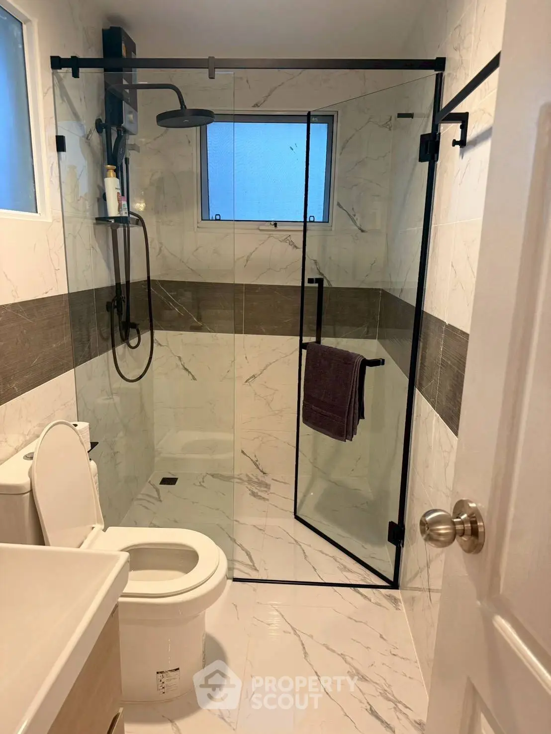 Modern bathroom with glass shower enclosure and sleek fixtures