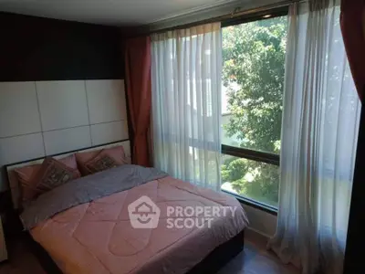 Cozy bedroom with large windows offering ample natural light and a serene tree-lined view, perfect for relaxation and tranquility in a modern home.