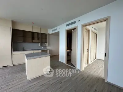 Modern open-plan kitchen with sleek cabinetry and island in a bright apartment.