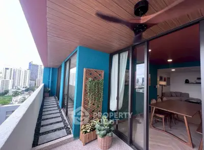 Stylish balcony with city view, modern ceiling fan, and cozy interior access.