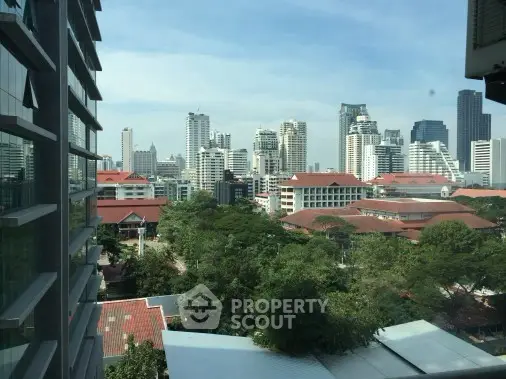 Stunning cityscape view from high-rise building with lush greenery and skyline.