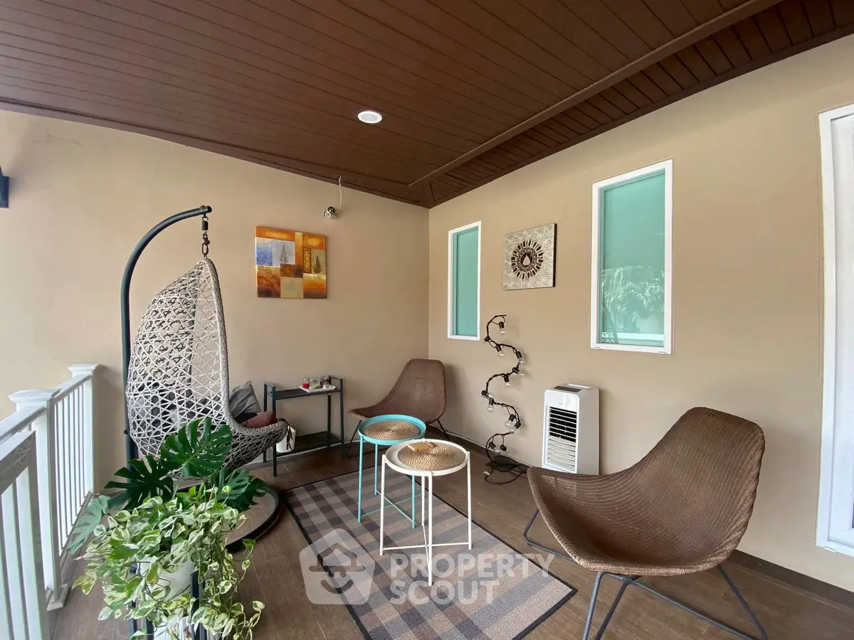 Charming balcony with cozy seating and modern decor, perfect for relaxation.