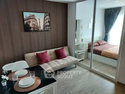 Modern apartment interior with cozy living room and stylish bedroom separated by glass doors.