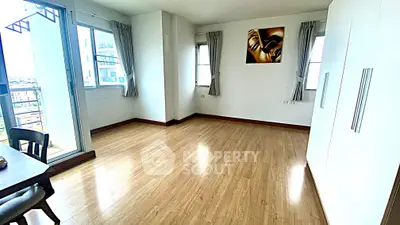 Spacious and bright room with wooden flooring and modern decor