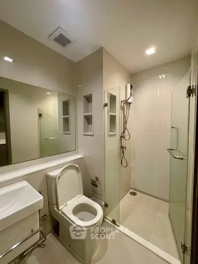 Modern bathroom with glass shower and sleek fixtures in a contemporary apartment.