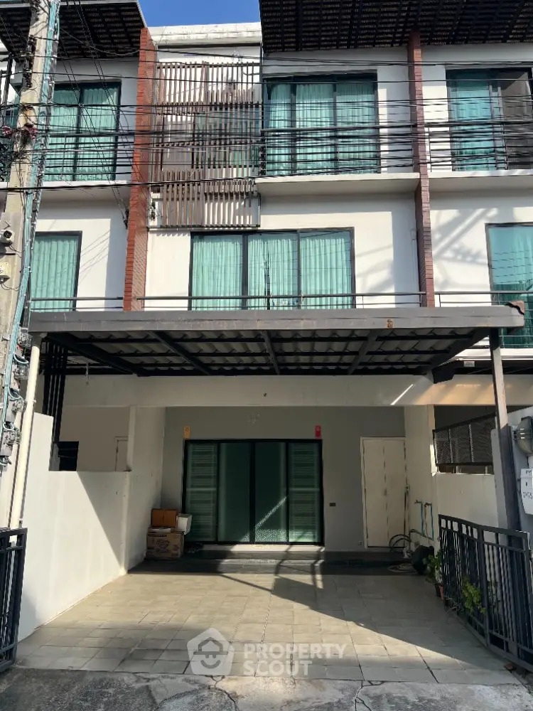 Modern three-story townhouse with gated parking and large windows