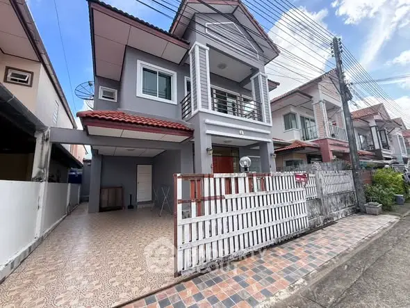 Charming two-story house with tiled driveway and balcony in a suburban neighborhood.