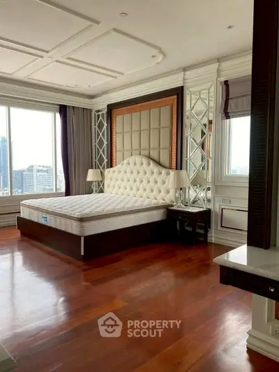Luxurious bedroom with elegant design and city view, featuring a plush bed and hardwood floors.
