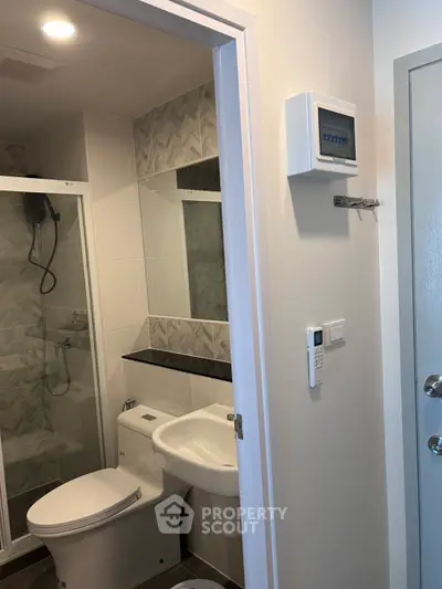 Modern bathroom with glass shower and sleek fixtures in a contemporary apartment.