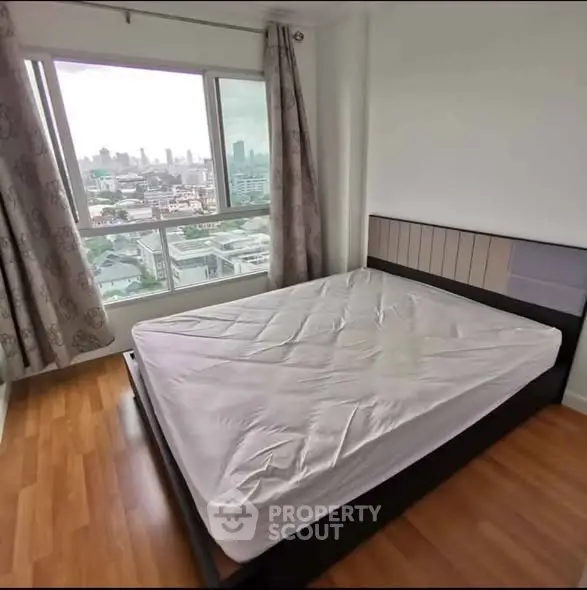 Spacious bedroom with city view and large window in modern apartment