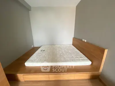 Minimalist bedroom with wooden platform bed and neutral walls