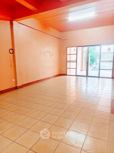 Spacious unfurnished room with tiled flooring and large windows, ideal for customization.