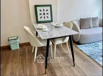 Modern living room with stylish dining table and cozy sofa, perfect for urban living.
